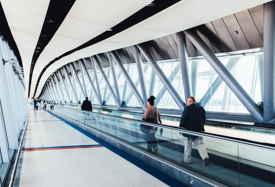 Travellers walking through a bright airport terminal