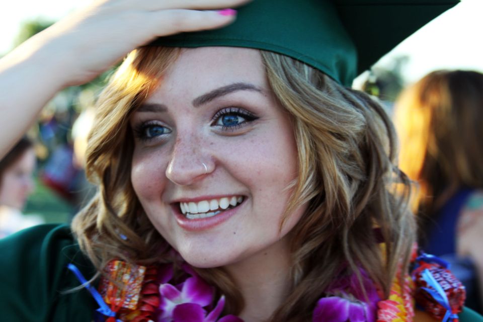 A smiling graduate in a cap and gown