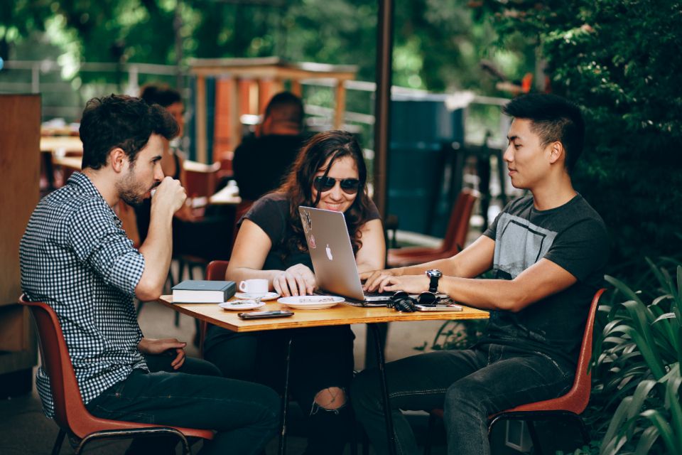 Three people talking around a café table